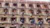 FILE - Indians climb the wall of a building to help students appearing in an examination in Hajipur, in the eastern Indian state of Bihar, March 18, 2014.