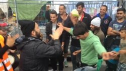 Syrian, Afghan refugees dance outside Vienna, Austria train station, Sept. 15, 2015.