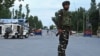 TOPSHOT - Security personnel stand guard a street during a lockdown in Srinagar on August 12, 2019. Indian troops clamped tight restrictions on mosques across Kashmir for Eid al-Adha festival, fearing anti-government protests over the stripping of…