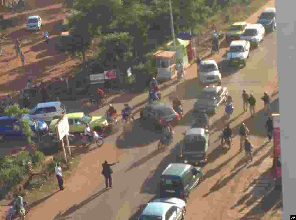 In this image made available by Malikahere.com security personnel, right, arrive close to the scene of an attack on a hotel in Bamako, Mali, Nov. 20, 2015. 